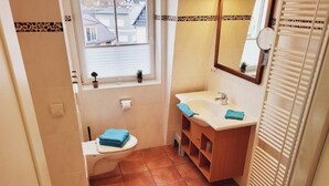 A bathroom with a toilet, sink, and shower.