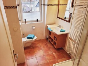 A bathroom with a toilet, sink, and shower. - (190) 3-room apartment lake view - Apartment house Baltic Sea beach (Kühlungsborn)