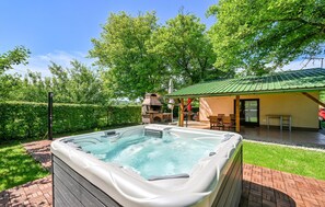 Ein Whirlpool im Garten mit Grillplatz und überdachter Terrasse.