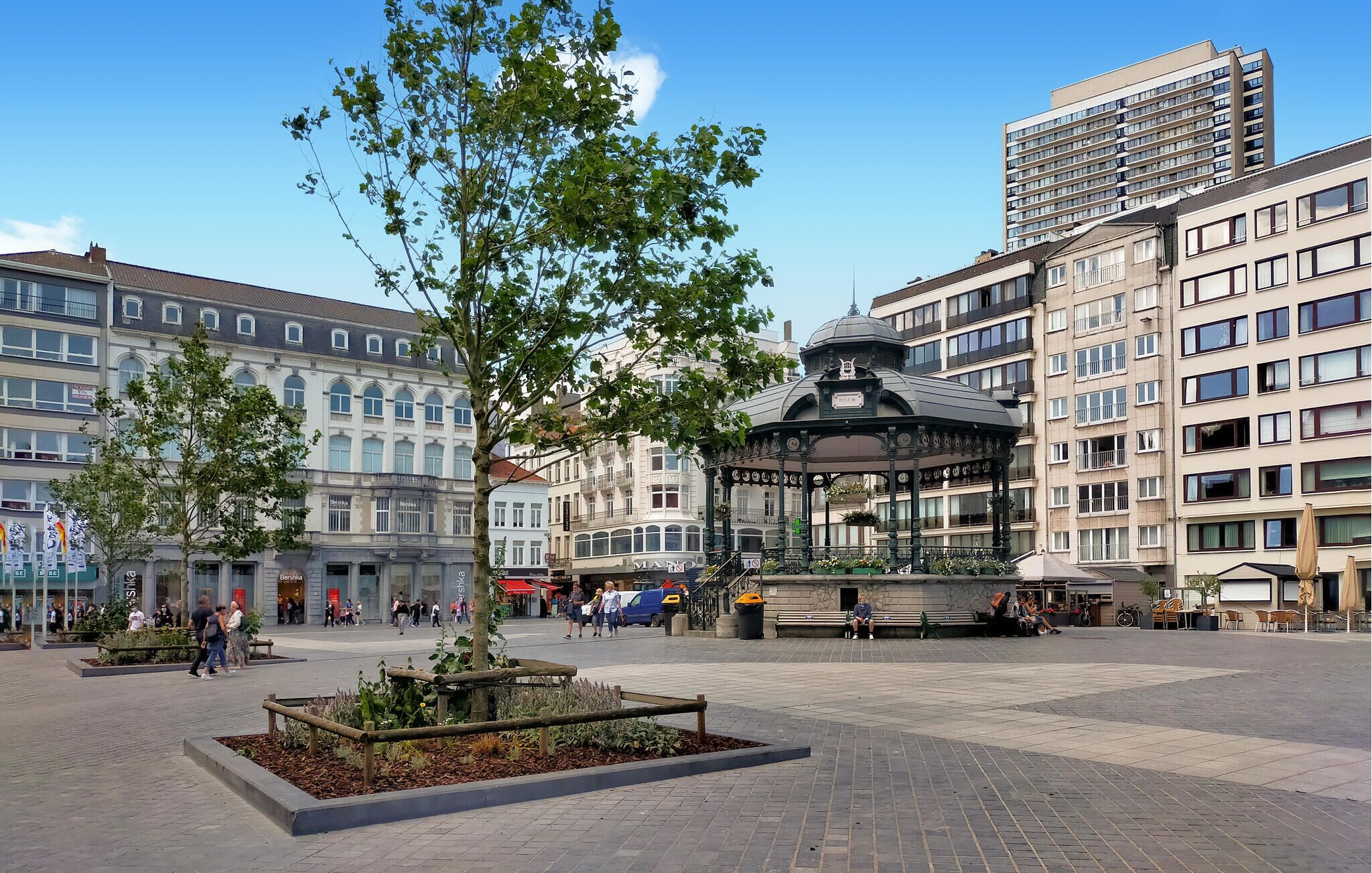 A public square with a gazebo, benches, and a tree.