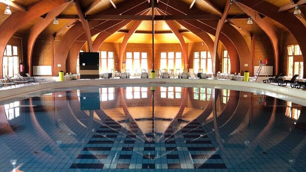 A large indoor swimming pool with a tiled floor and a high, arched wooden ceiling. - Holiday home in a quiet location with terrace (Agárd)