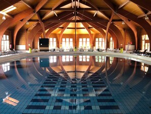 A large indoor swimming pool with a tiled floor and a high, arched wooden ceiling. - Holiday home in a quiet location with terrace (Agárd)