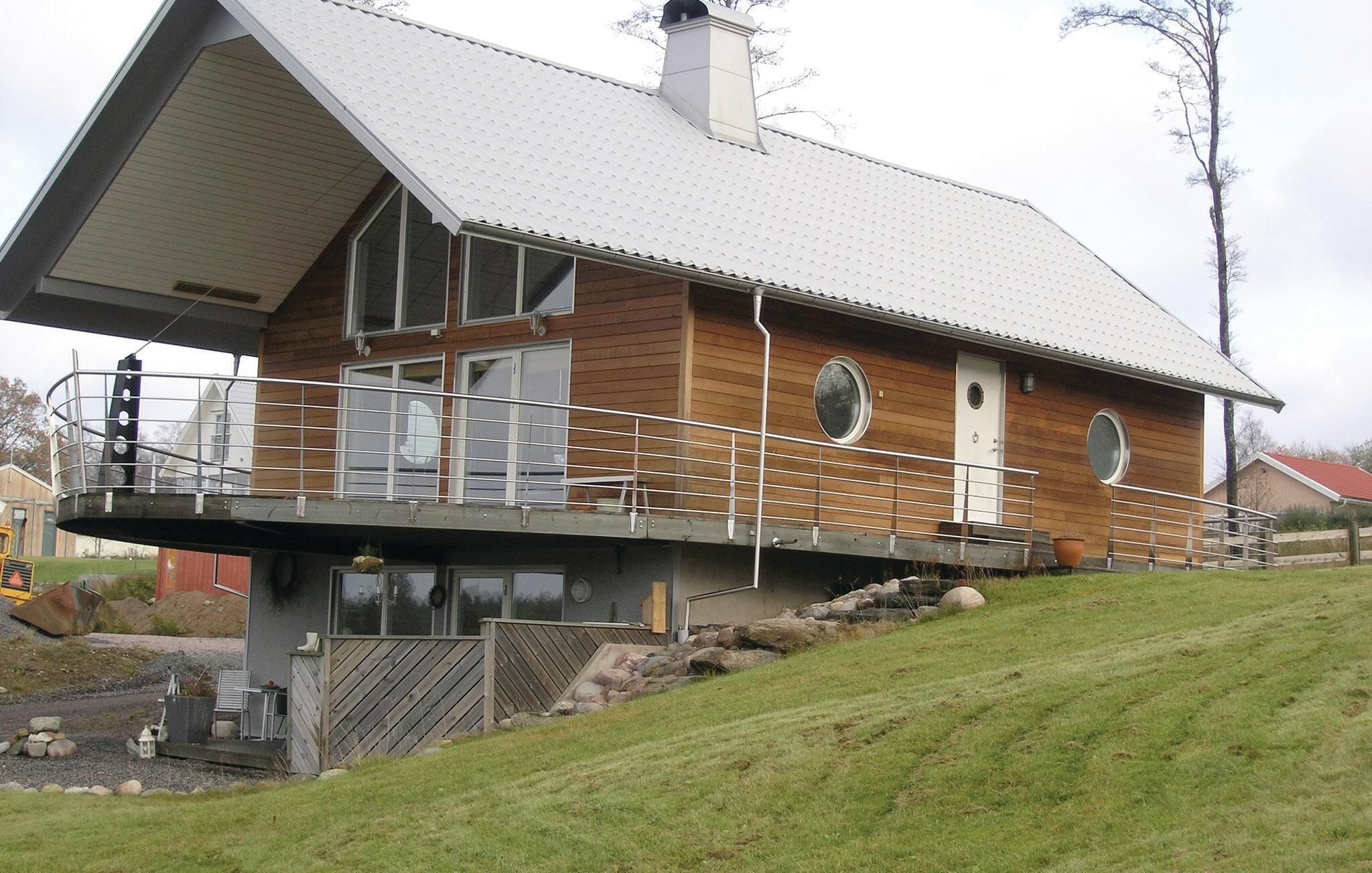 Et moderne hus med stor terrasse, overdækket veranda og et skråt tag.