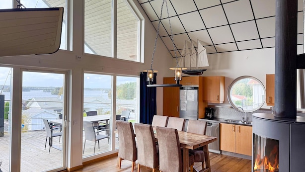 A spacious room with a large dining table, wooden chairs, a kitchen area, and a fireplace. - 1 bedroom amazing home in Månsarp (Månsarp)