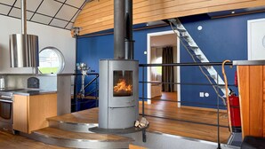 A modern kitchen with a wood-burning stove, a stainless steel range, and a built-in oven. - 1 bedroom amazing home in Månsarp (Månsarp)