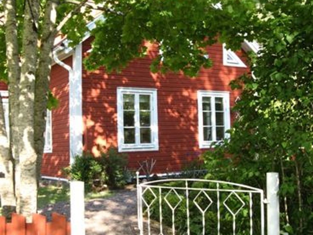 A red house with white trim and a metal gate.