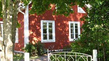 A red house with white trim and a metal gate.