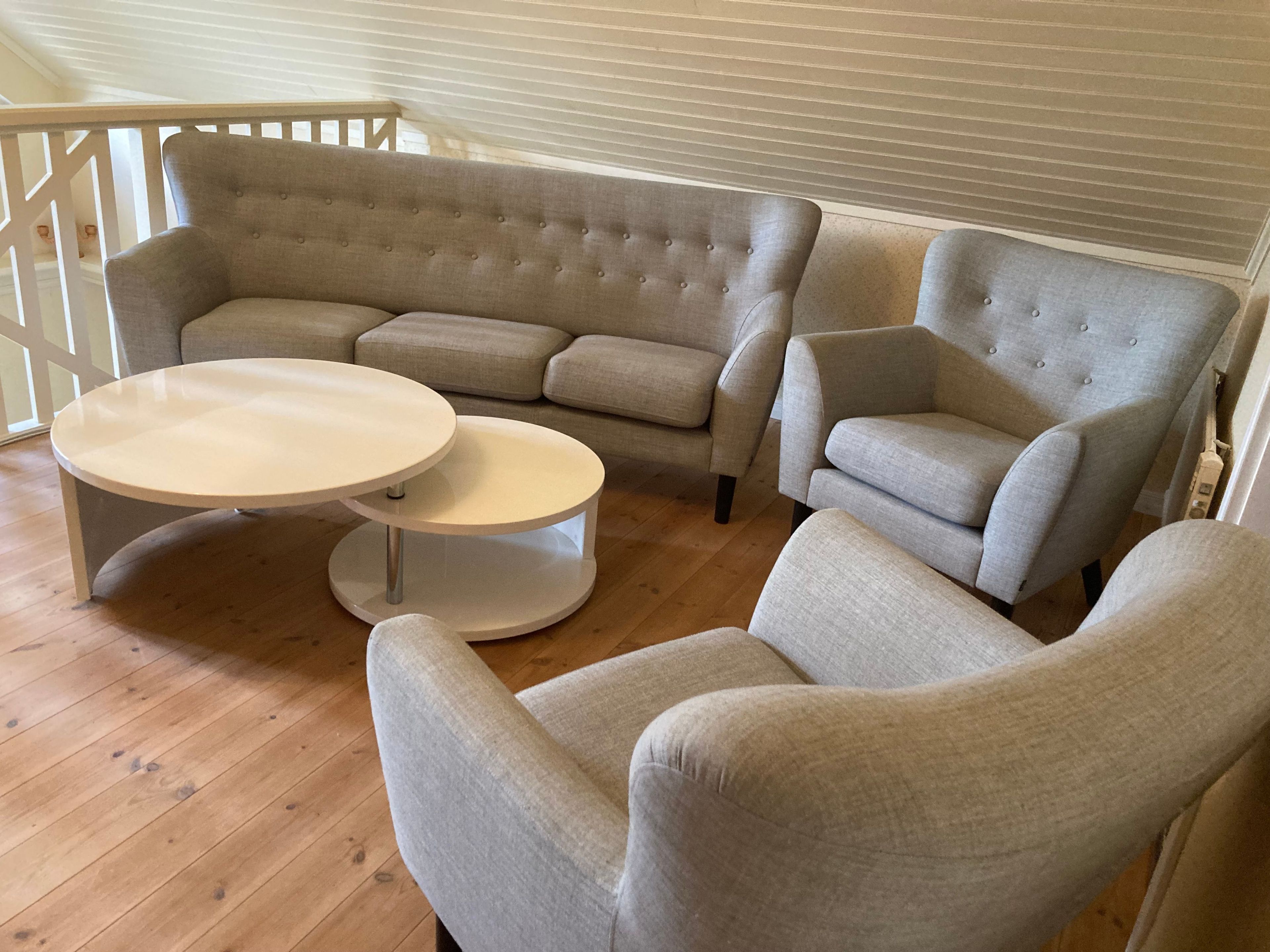 A living room with a sectional sofa, two armchairs, and a round coffee table.