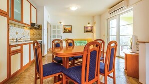 Un coin repas avec une table et des chaises en bois, une cuisine avec des placards en bois et une grande fenêtre donnant sur un beau paysage.