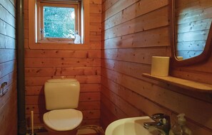 Bathroom features a toilet, sink, and mirror, with a small window above the toilet.