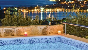 A poolside area with a view of a cityscape at night.