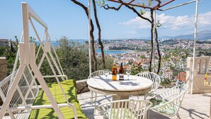 An outdoor seating area with a table and chairs, overlooking a cityscape.