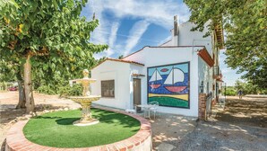 Un petit bâtiment orné d’une fresque murale, avec une fontaine et un espace patio.