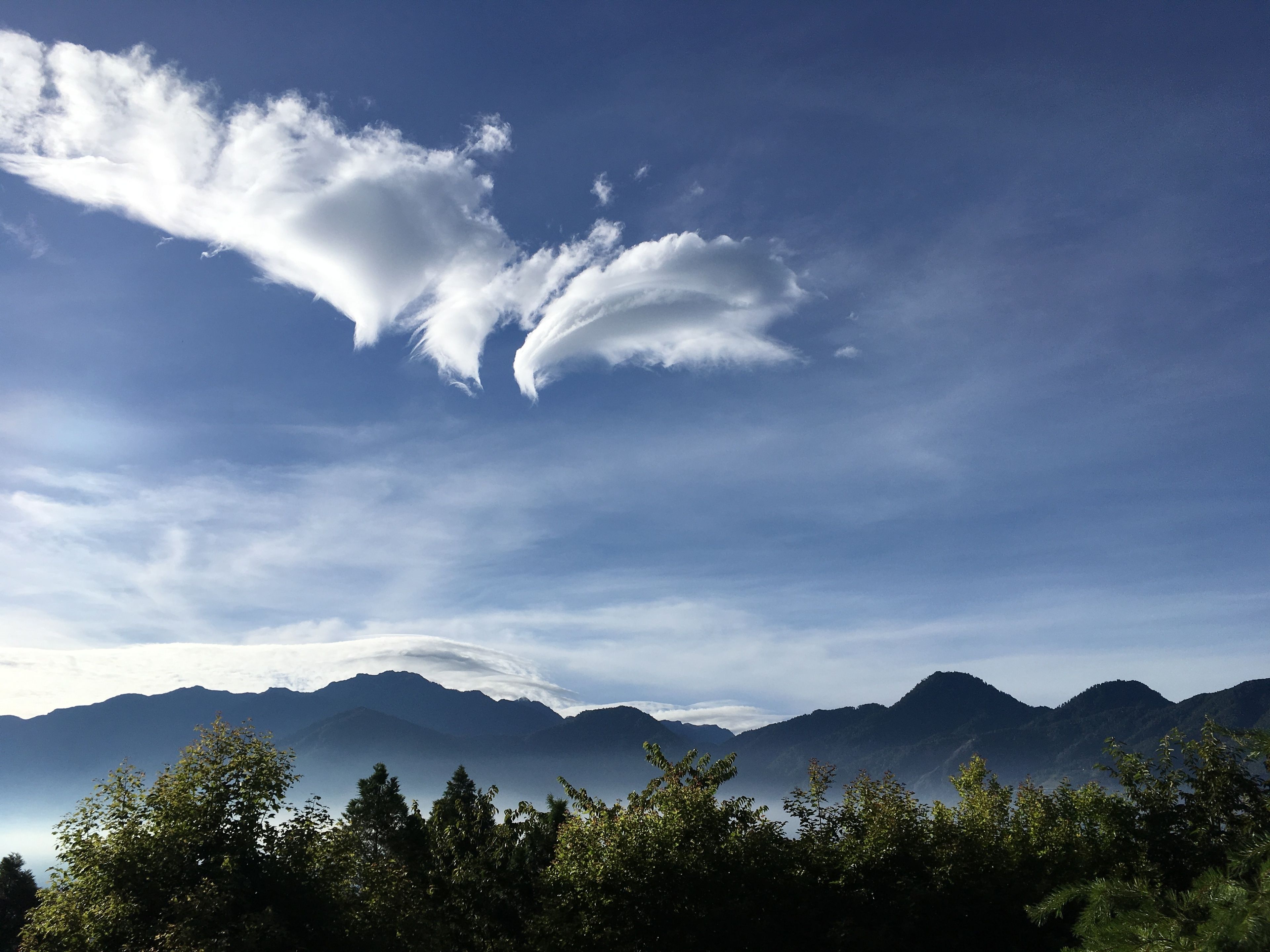 A mountain landscape with a clear sky and clouds.