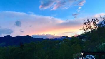 A view of a mountainous landscape with a sunset.