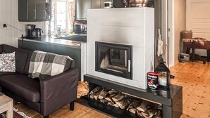 A cozy living room with a fireplace, a sofa, and a coffee table. - Amazing home in Kvam with kitchen (Kvam)