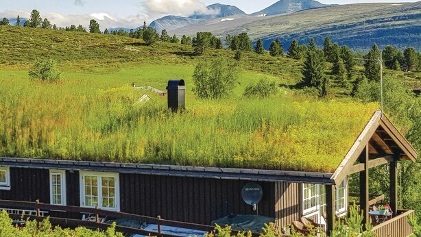 A cabin with a deck and a view of a grassy field and mountains. - Amazing home in Kvam with kitchen (Kvam)