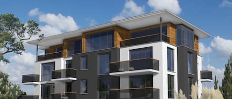 A modern multi-story building with balconies, large windows, and a well-maintained lawn.