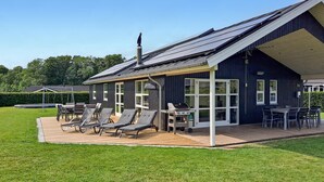 A modern house with a covered patio, outdoor seating, and a barbecue area. - Awesome home in Aabenraa with sauna (Aabenraa)