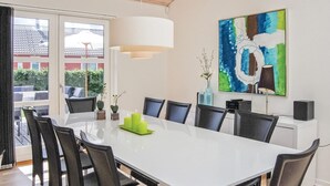 A modern dining area with a white table, black chairs, and a large abstract painting on the wall. - Awesome home in Aabenraa with sauna (Aabenraa)