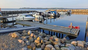 A marina with boats docked at wooden piers, surrounded by a rocky shoreline. - Awesome home in Aabenraa with sauna (Aabenraa)