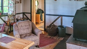 Una sala de estar acogedora con un sillón de mimbre, una mesa de madera y una chimenea.
