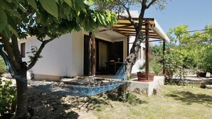 A house with a hammock, a patio, and a garden.