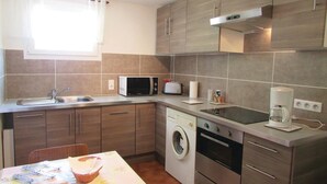 A compact kitchen with a washing machine, microwave, toaster, and coffee maker. - 1 bedroom beautiful home in Calvi (Calvi)