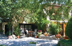 An outdoor seating area with a table and chairs, surrounded by potted plants and a stone wall. - 1 bedroom amazing apartment in Lorgues (Lorgues)