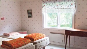 A bedroom with two single beds, a desk, and a window with floral curtains. - 2 bedroom nice home in Töcksfors (Töcksfors)