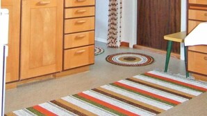 A kitchen with wooden cabinets, a coffee maker, and a striped rug. - 2 bedroom nice home in Töcksfors (Töcksfors)