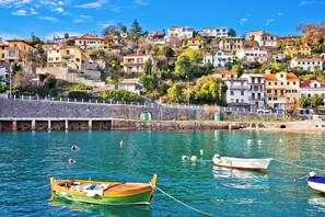 A coastal village with houses on a hillside, a stone pier, and boats in the water. - Studio in a quiet location (Ika)