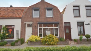 A two-story house with a brick facade, a small porch, and a white door. - Stunning home in Breskens with WiFi (Breskens)