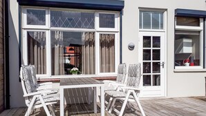 A wooden deck with a table and four chairs. - Stunning home in Breskens with WiFi (Breskens)