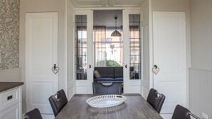 A dining area with a wooden table, four chairs, and a decorative tray. - Stunning home in Breskens with WiFi (Breskens)