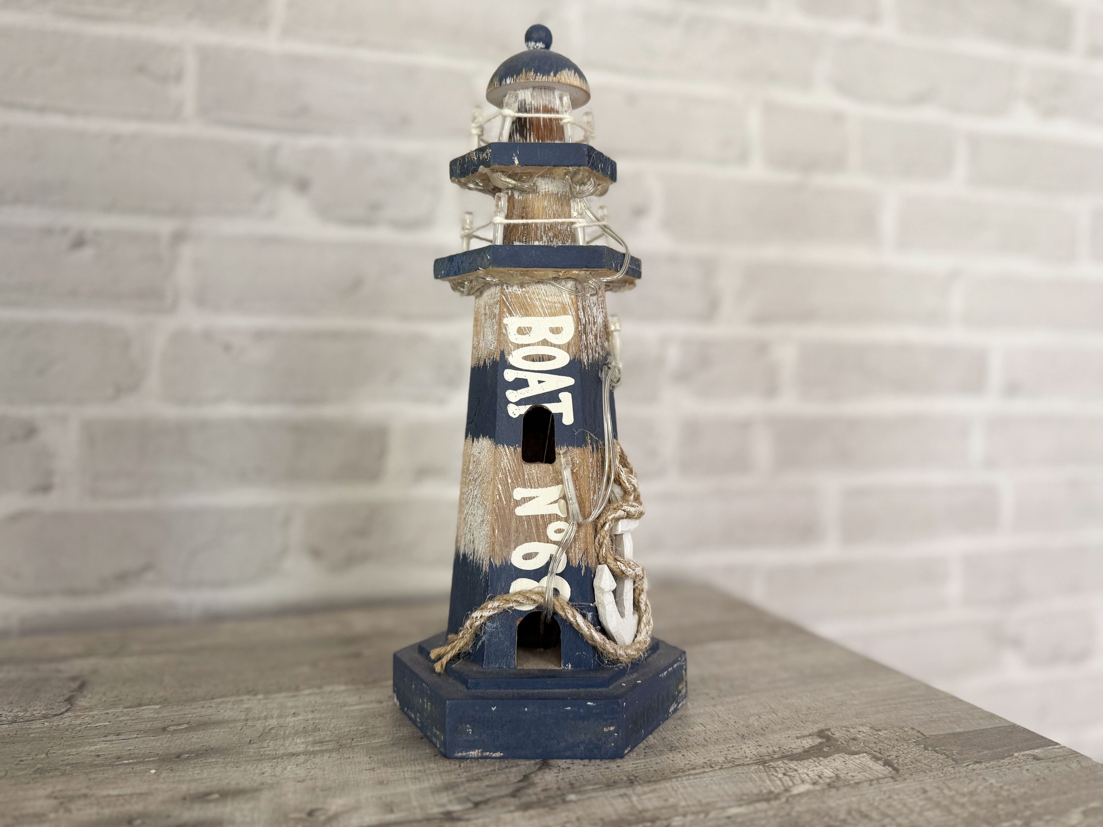 A lighthouse model with the inscription "BOAT NO 8" and a rope tied around it.