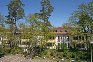 Ein mehrstöckiges Gebäude mit großen Fenstern und einem roten Ziegeldach.