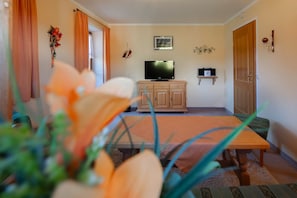 A living room with a television, wooden cabinet, and a small shelf. - Apartment 2 - Vacation Lohbinder (Fam. Holzer) (Rottach-Egern)