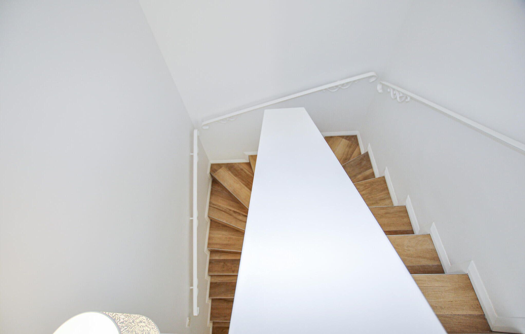A staircase with wooden steps and white walls.