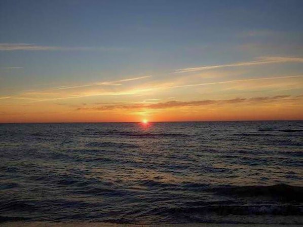 A sunset over the ocean with a clear horizon.