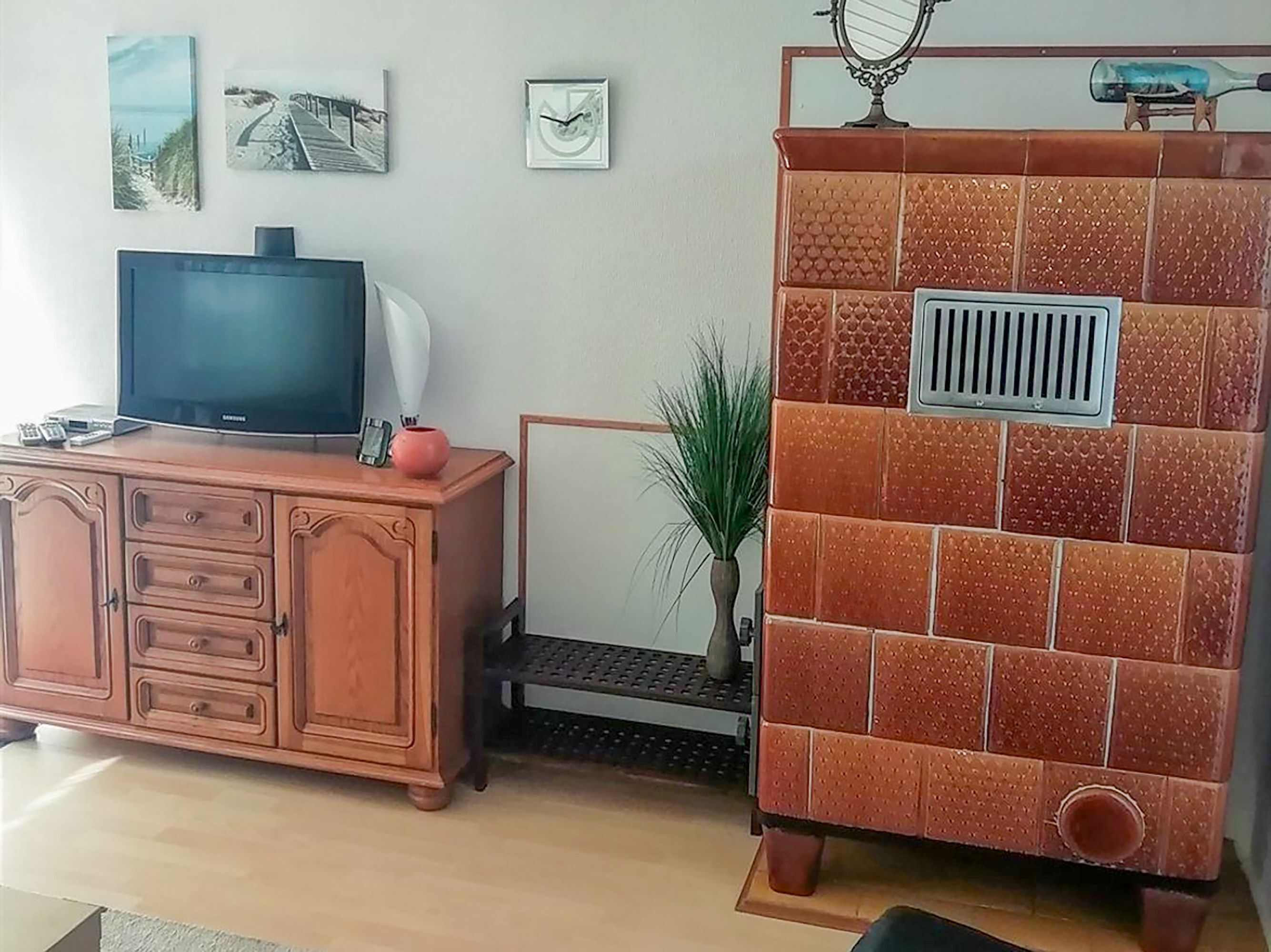 Ein Wohnzimmer mit Fernseher, Schrank und dekorativen Wandfliesen.