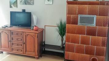 Ein Wohnzimmer mit Fernseher, Schrank und dekorativen Wandfliesen.