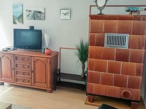 Un salon avec un téléviseur, un meuble et des carreaux décoratifs sur le mur.