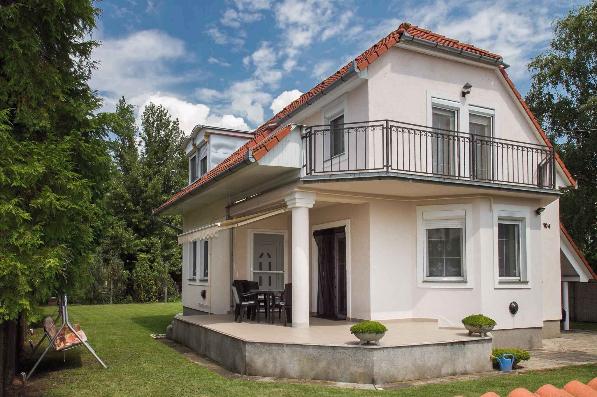 Une maison à deux étages dotée d’un balcon, d’un porche abrité et d’une pelouse bien entretenue.