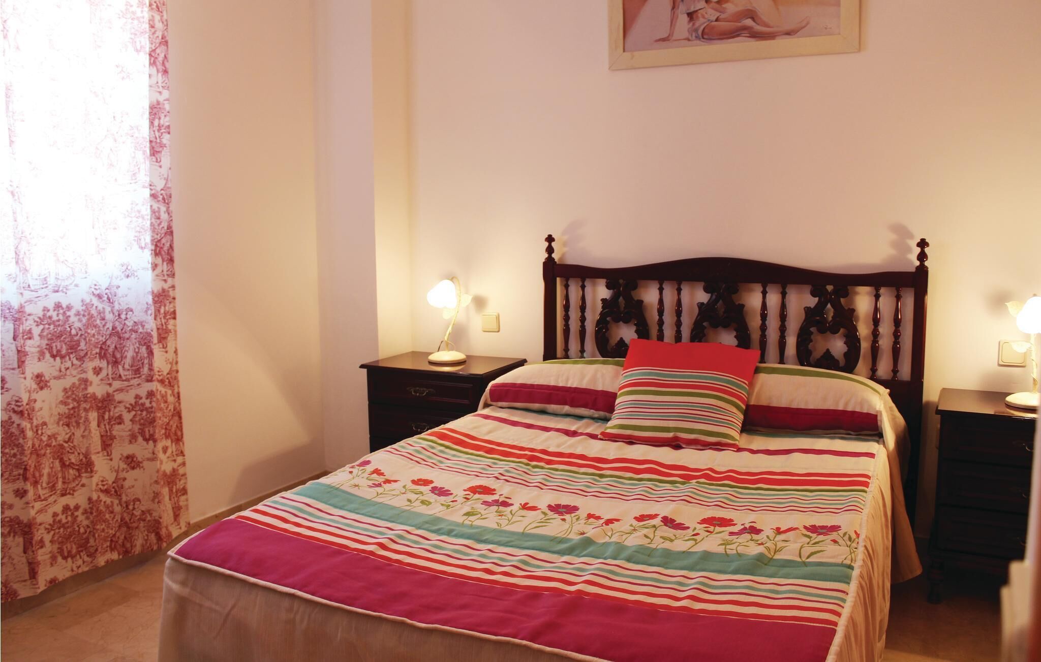 Une chambre à coucher avec un cadre de lit en bois, une literie à rayures et deux lampes de chevet.