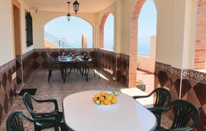 A dining area with a table set for four, surrounded by chairs, and a bowl of fruit on the table. - Stunning home in Torrox (Torrox)