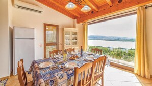 A dining area with a table set for four, a refrigerator, a cabinet, and a view of a lake. - Beautiful home in Sambuca di Sicilia AG (Sambuca di Sicilia AG)