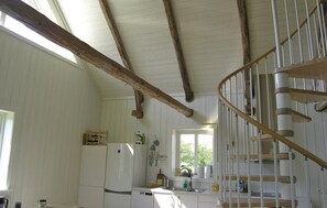 A kitchen with wooden beams, a white refrigerator, a sink, and a spiral staircase. - 1 bedroom nice home in Lidhult (Lidhult)