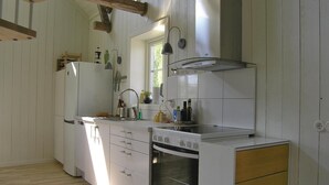 Una cucina compatta con mobili bianchi, forno integrato, lavello e una finestra che offre luce naturale.