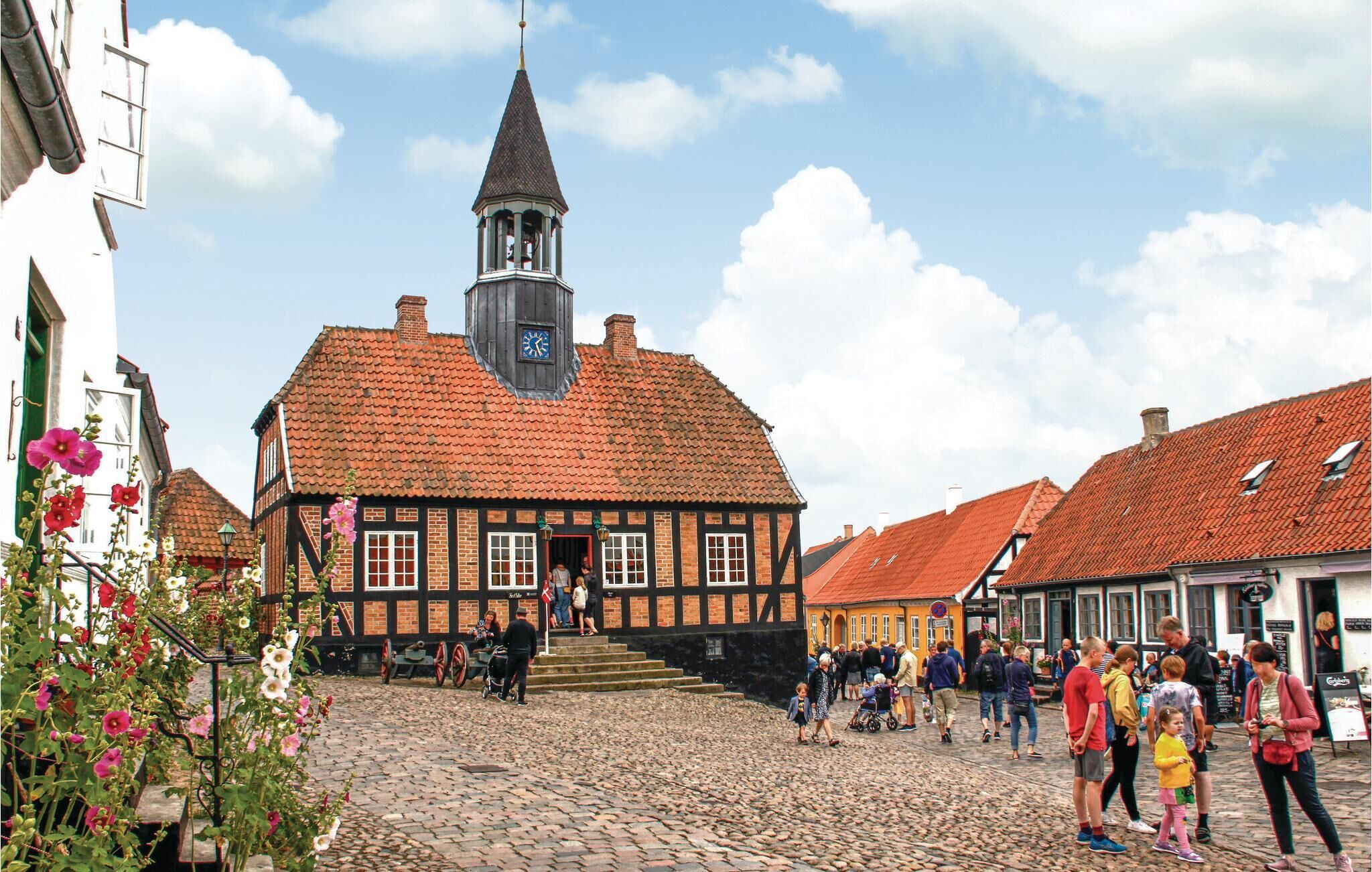A historic building with a clock tower, cobblestone street, and traditional architecture.